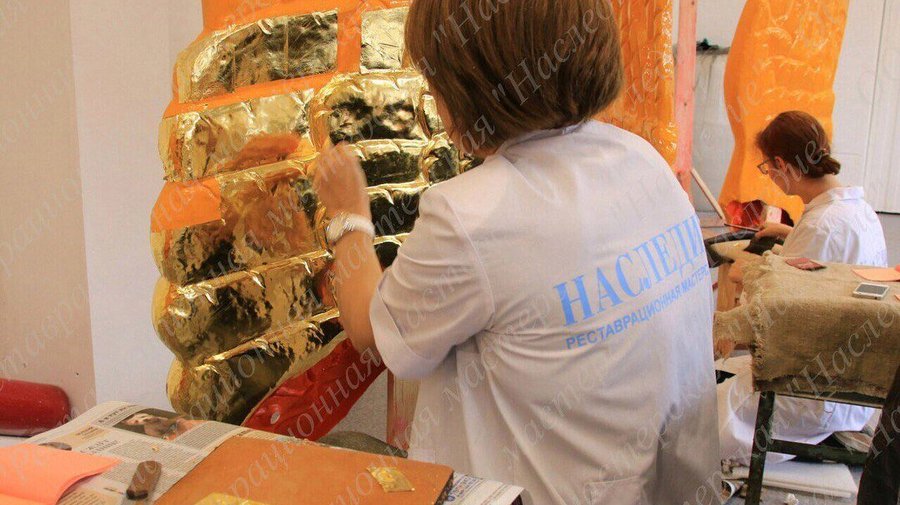 Реставраторы наносят позолоту на крылья грифонов с Банковского моста
