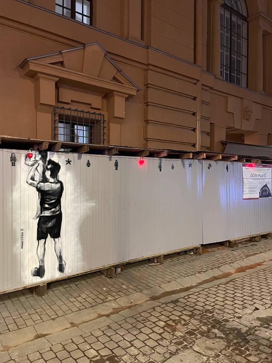 Художник нарисовал новогодний стрит-арт на строительном заборе у Дома радио