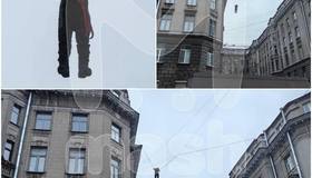 На улице Правды дворник сорвался с крыши и повис на проводах. Прохожие в растерянности наблюдают за происходящим и фотографируют мужчину, пока к нему спешат спасатели. : Mash