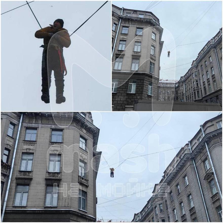 На улице Правды дворник сорвался с крыши и повис на проводах. Прохожие в растерянности наблюдают за происходящим и фотографируют мужчину, пока к нему спешат спасатели. : Mash