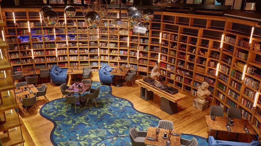 Библиотечный зал Community: книжные стеллажи, столы, кресла и зеркальные шары